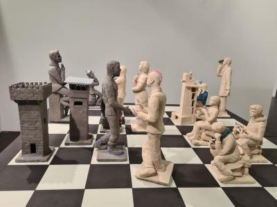 Schachaufstellung bei der Weiß (Vordenker) gegen Schwarz (Querdenker) gewinnt, bestehend aus 17 Figuren aus Terracotta.